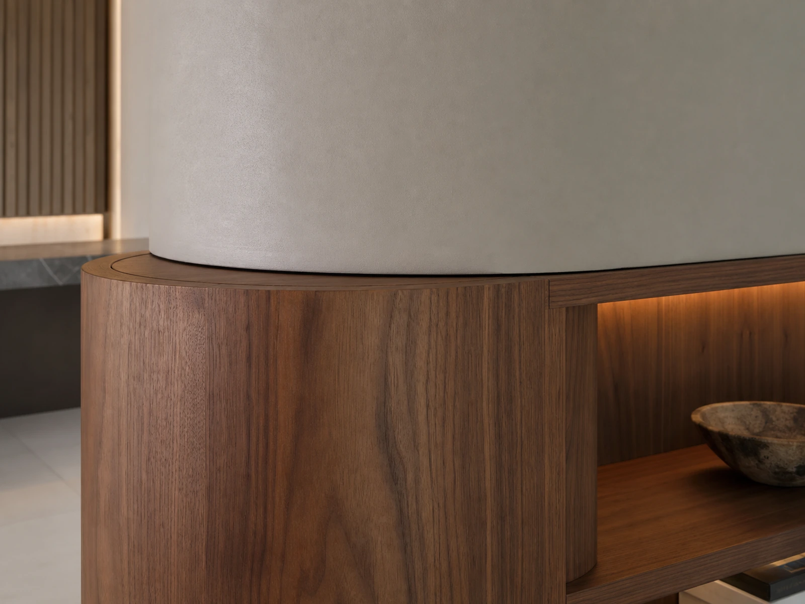 Curved walnut cabinet panel meeting a structural column with clean shelving and concealed lighting.