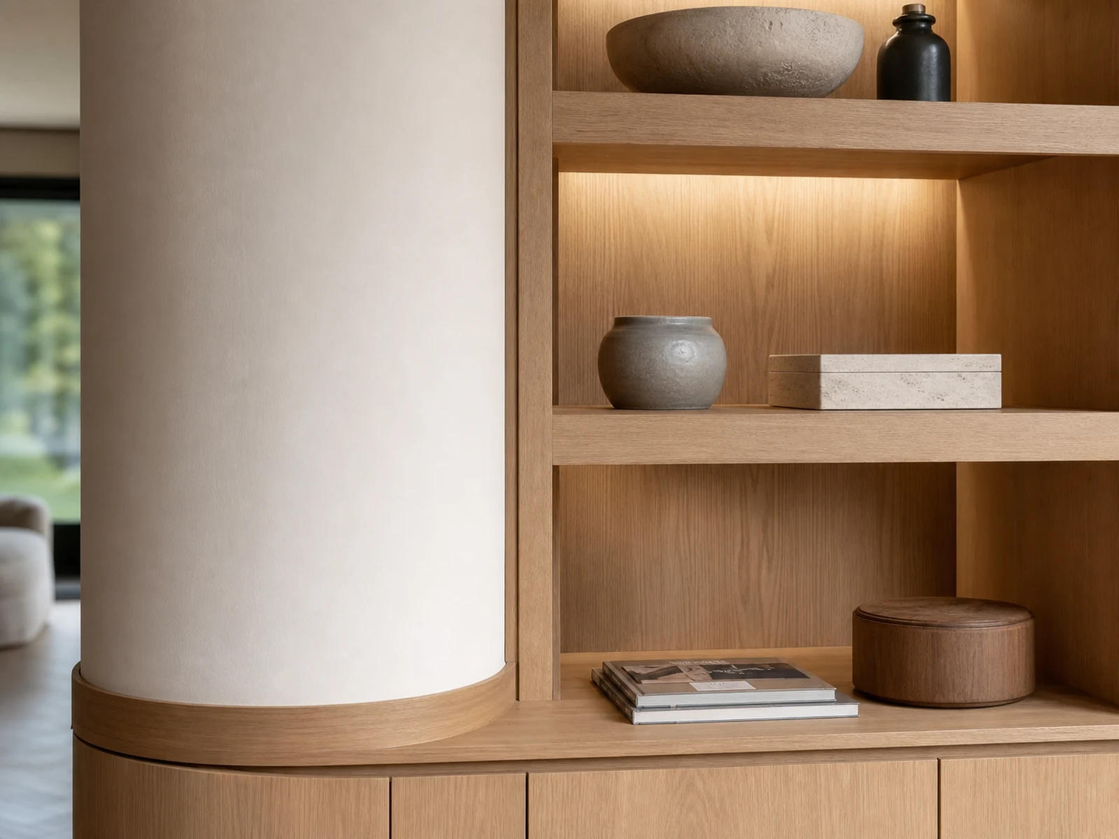 Round structural column surrounded by a custom display cabinet with open shelves and soft lighting.