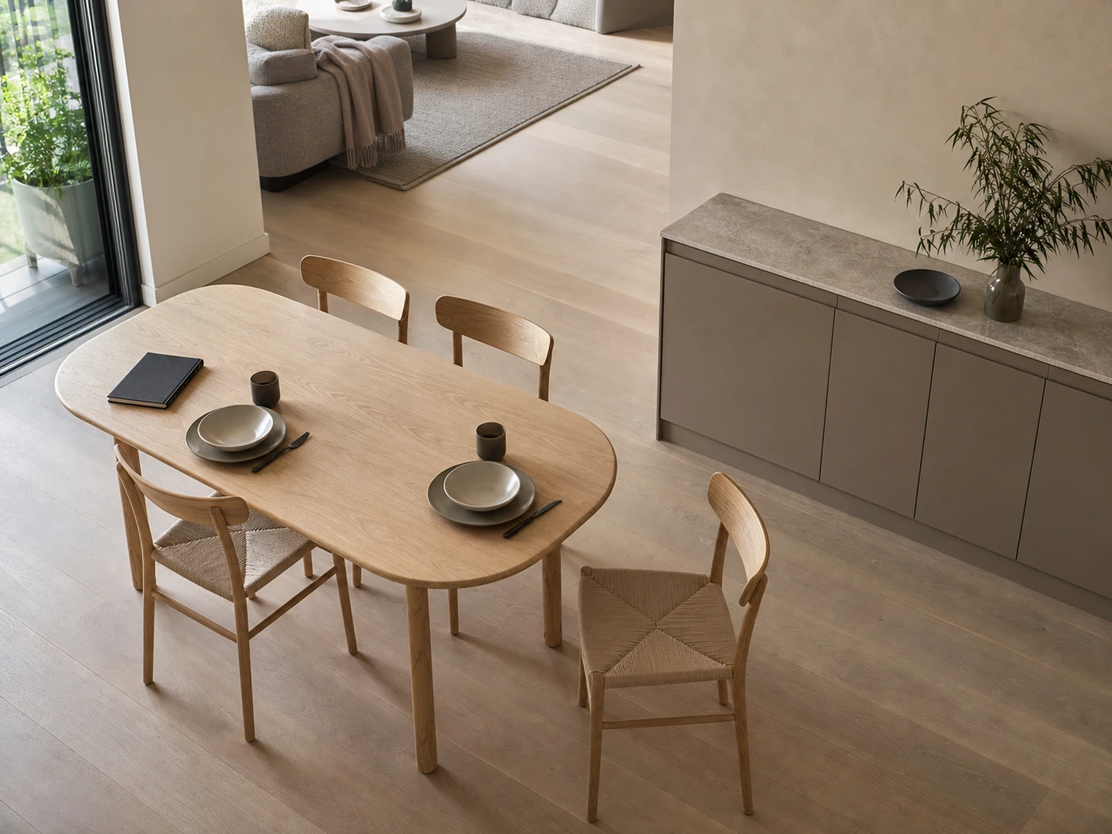 Elevated dining room layout showing tucked and pulled-out chairs, a low sideboard, and an open circulation strip.