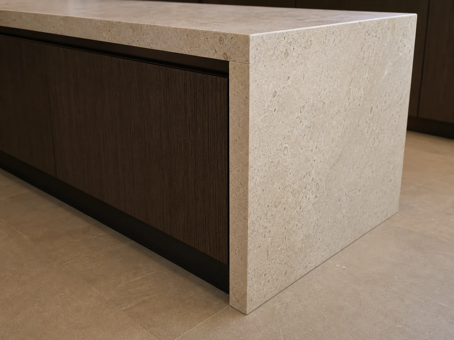 Waterfall stone island edge with countertop, cabinet base, planned joint, and finished floor contact.