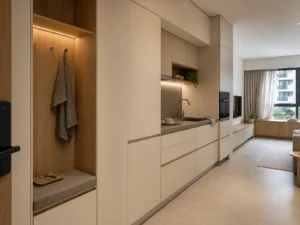 Compact apartment built-in cabinet set coordinating warm-white entry kitchen and living storage with light-oak accents.